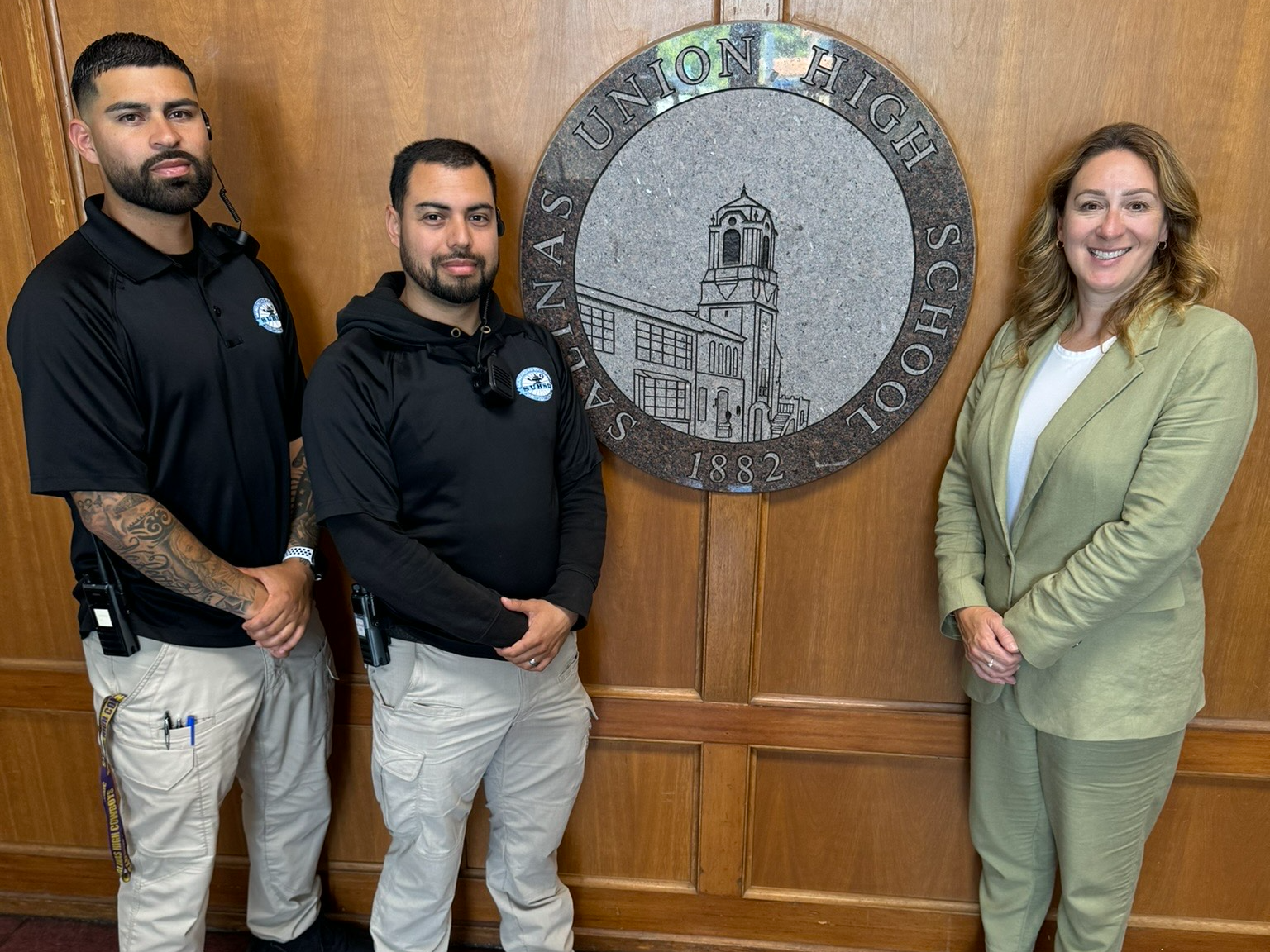 3 salinas high staff members standing by a salinas high plaque 